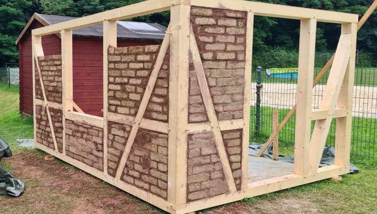 Kinder lernen bauen mit Holz und Lehm